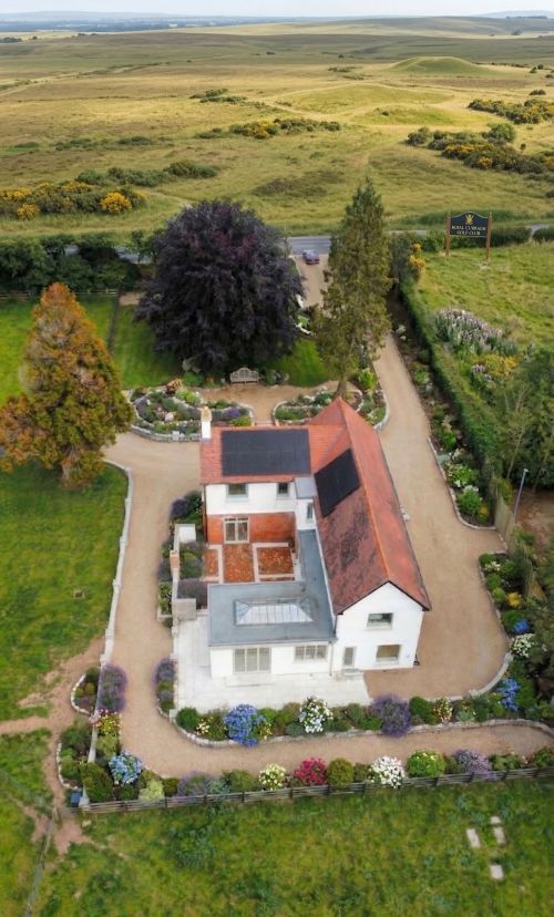 Luxurious dining room with classic furniture and a view of a vibrant garden through a large window.